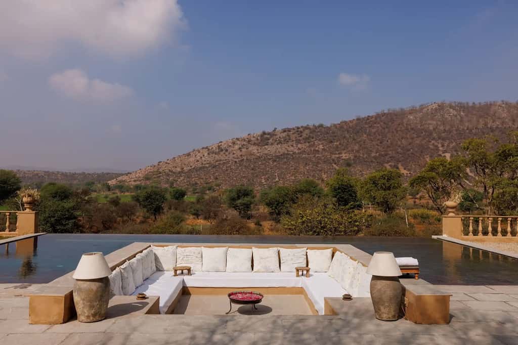 Infinity pool with white daybeds facing hills