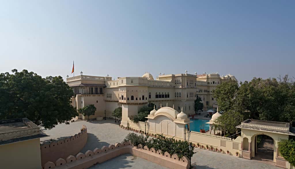 The palace seen from the outer wall, chhatris along the roofline and the pool at the side