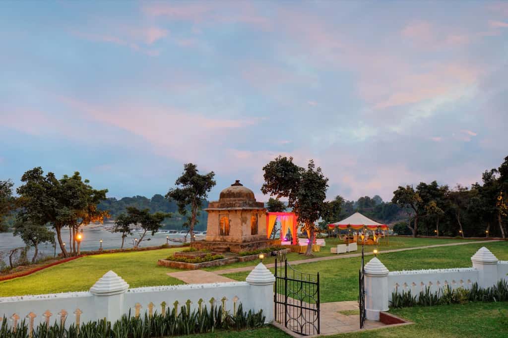 Stone cenotaph on the lawn at dusk with the river beyond