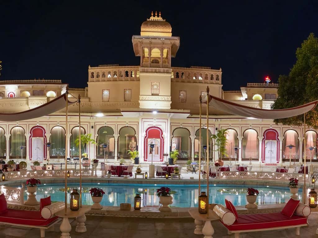 Lit palace and swimming pool at night