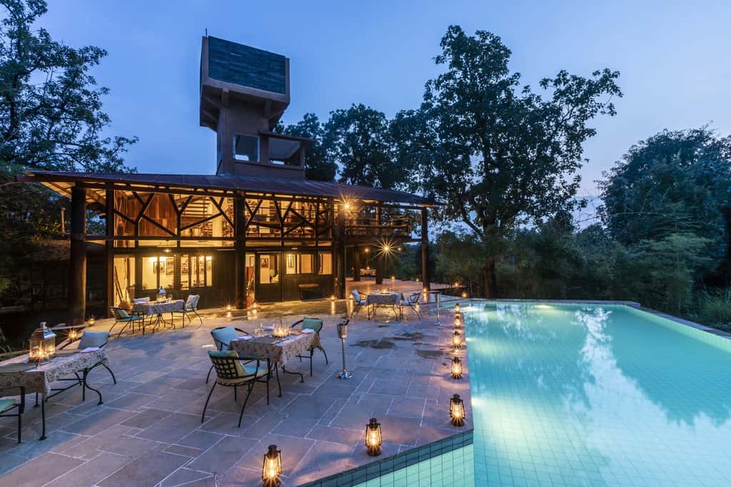 The pool and dining building at Pench Tree Lodge at dusk