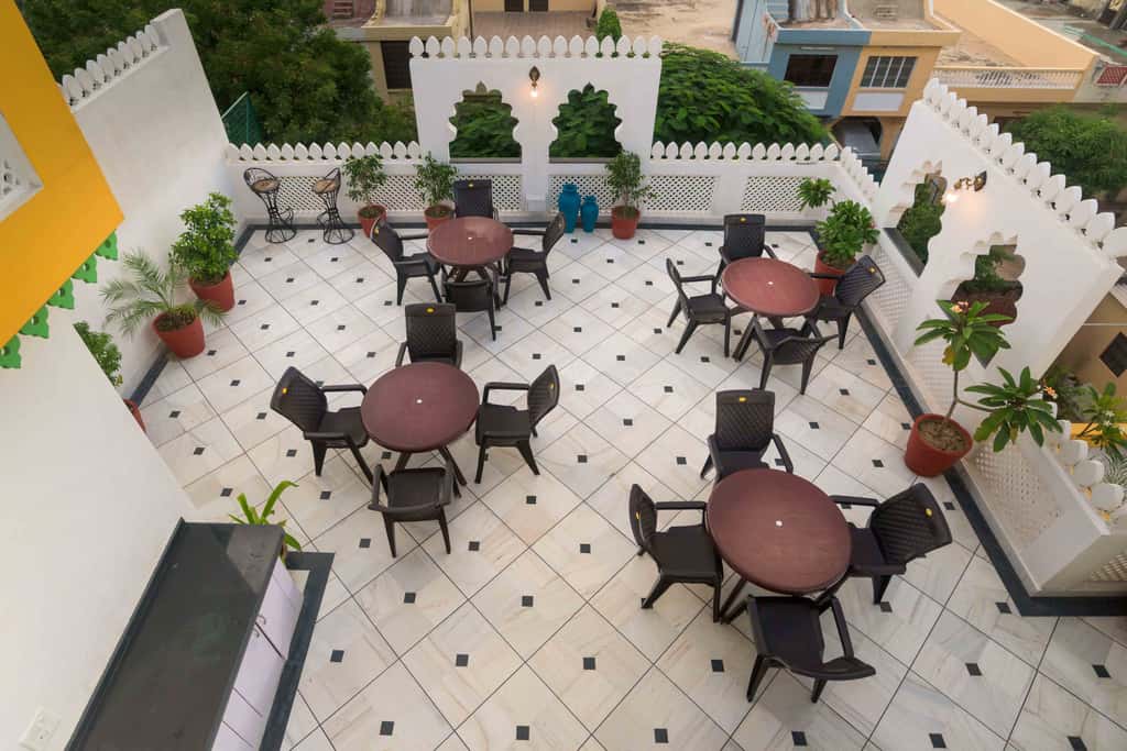 Crenellated second-floor terrace with round tables and planters