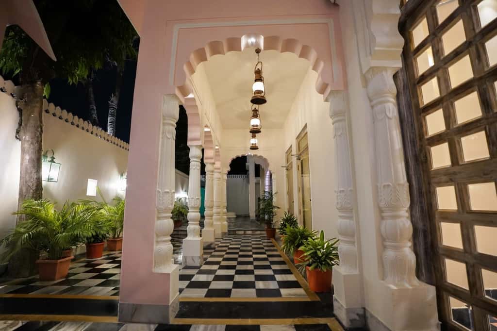 Pink scalloped arches and lanterns along the entrance arcade at Dev Mahal, Jaipur