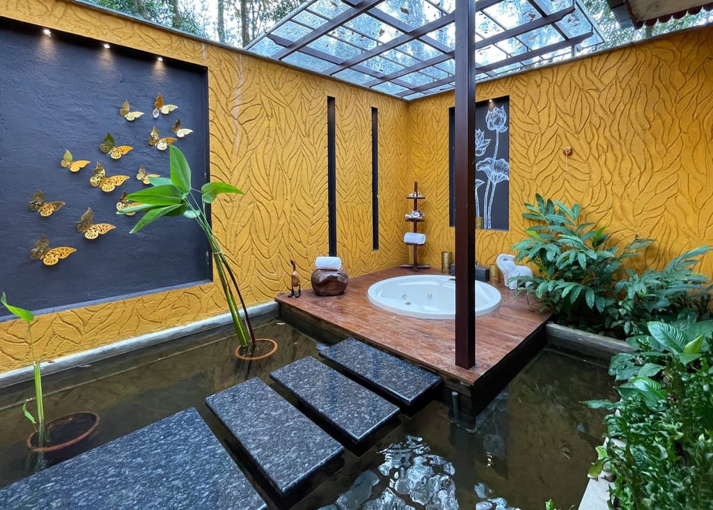 Prana Jacuzzi Cottage open-air jacuzzi court with glass roof, koi pond and stepping stones at Anantya by the Lake, Chittar