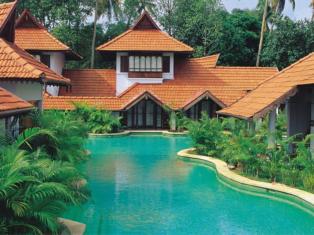 Meandering Pool Duplex Villas with tiered tiled roofs rising above the winding pool, Kumarakom Lake Resort, Kumarakom