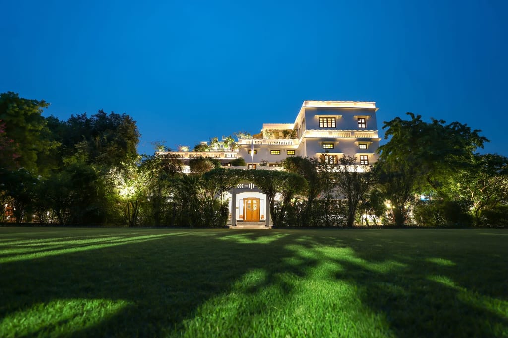Front lawn and lit Art Deco facade at dusk, Saraca Hotel Lucknow, Lucknow