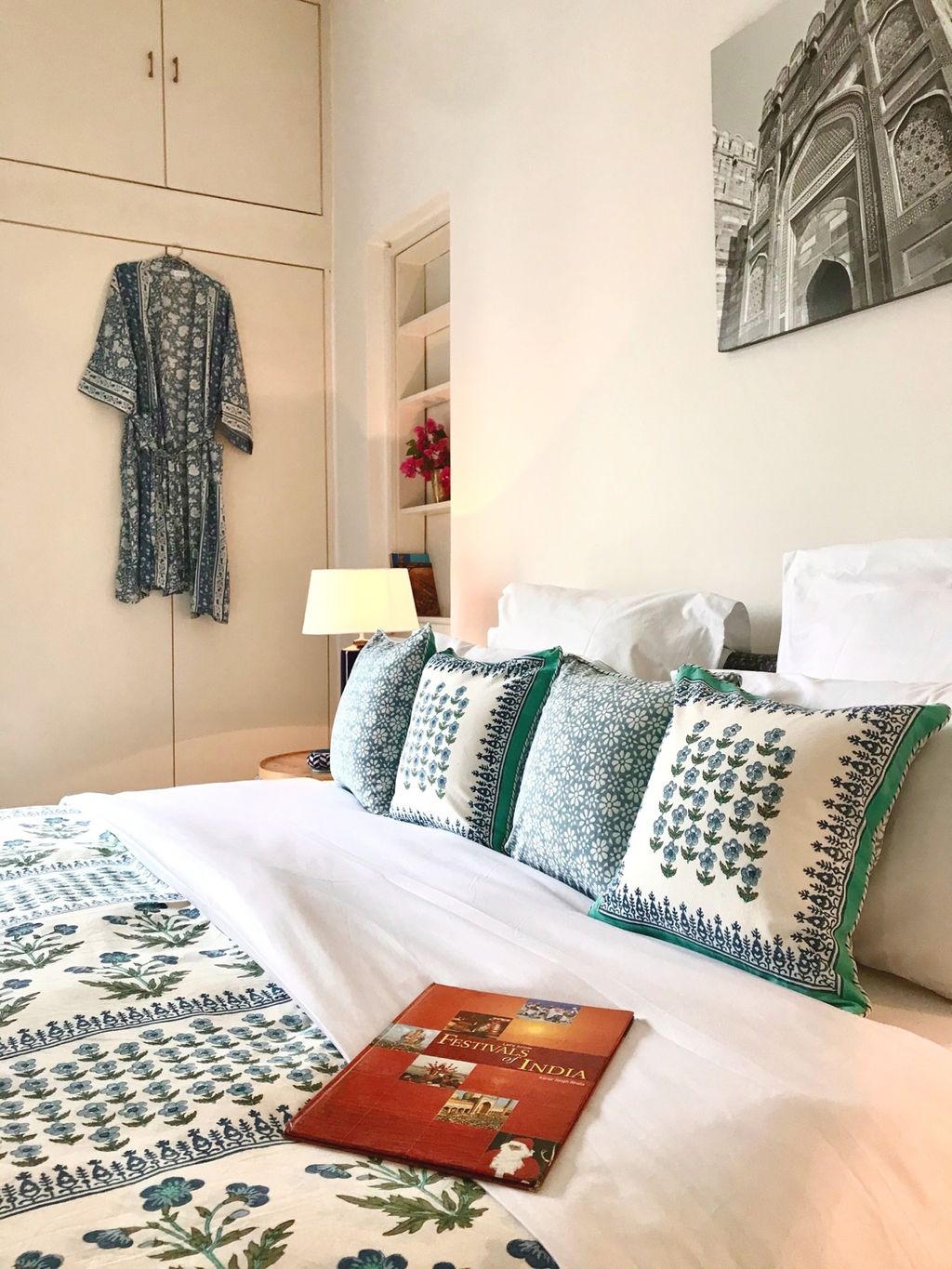 Guest bedroom with block-print quilt and cushions and a printed robe on the wardrobe, Mizpah Delhi, Delhi