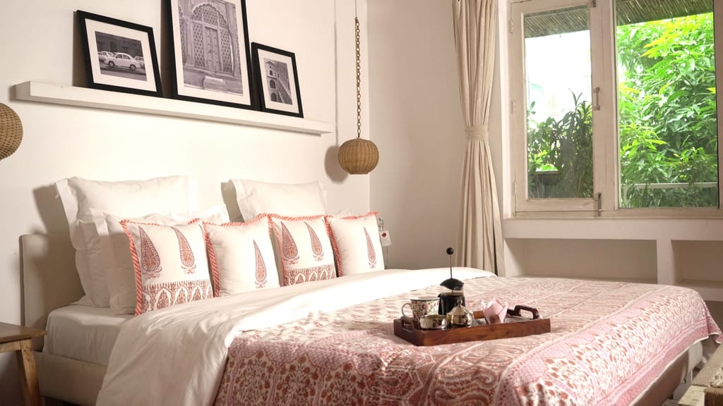 Guest bedroom with block-print bedspread, tea tray and a window onto greenery, Mizpah Delhi, Delhi