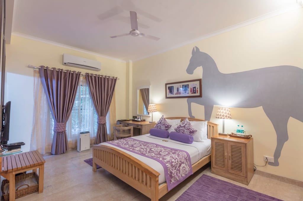 Standard Room with a light-wood double bed, air purifier and mauve curtains, Colonel's Retreat, Delhi