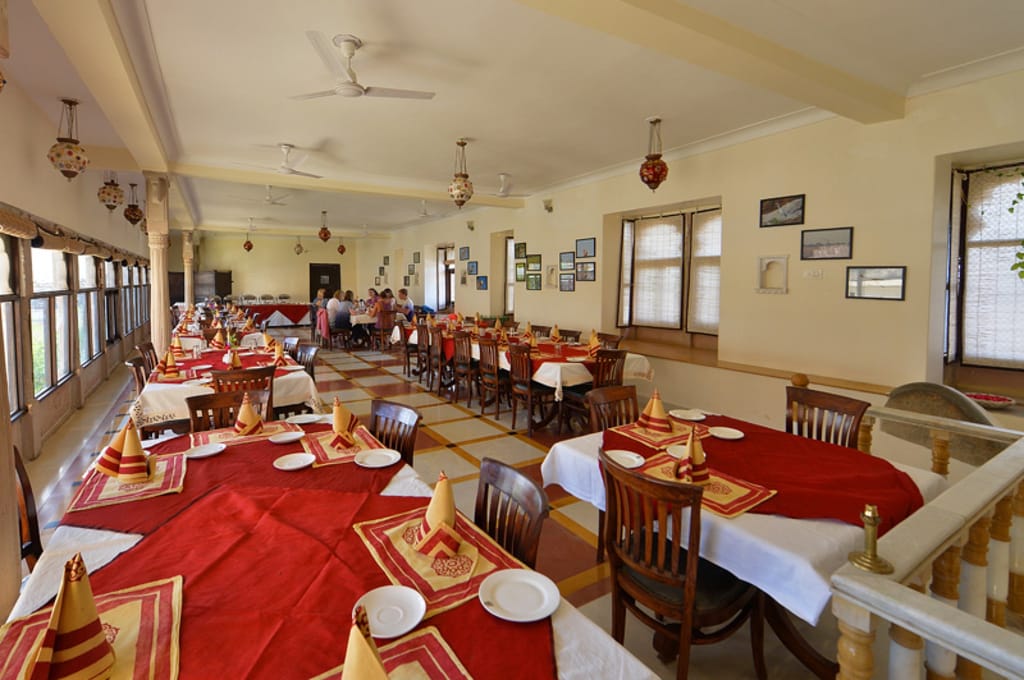 Dining room laid with red table linen, Castle Bijaipur, Bijaipur