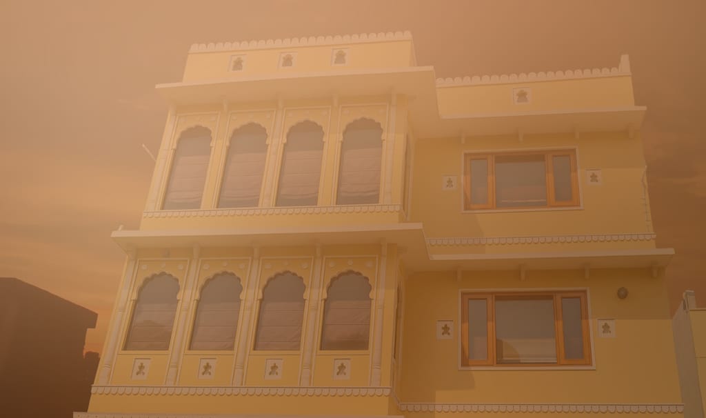 Yellow Rajasthani-style facade with scalloped arches and jharokha windows, Diwan House, Agra