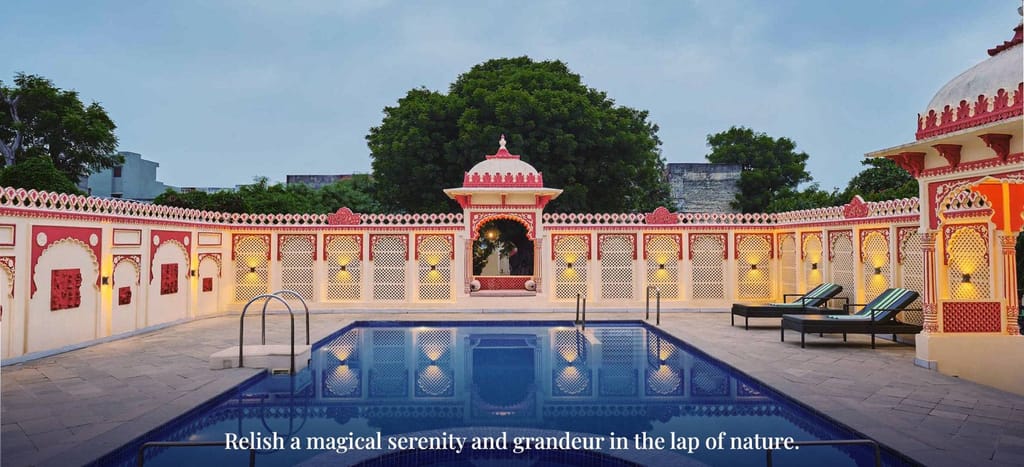 Swimming pool framed by red-and-cream lattice walls and a domed pavilion, Fort Dhariyawad, Dhariyawad