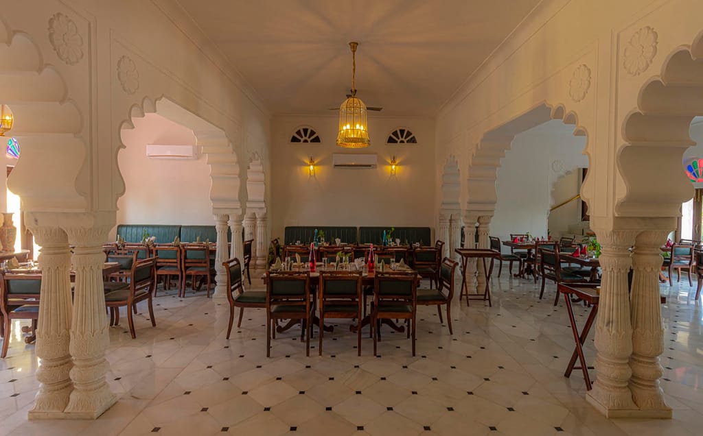Indoor restaurant with carved marble pillars and scalloped arches, Fort Dhariyawad, Dhariyawad