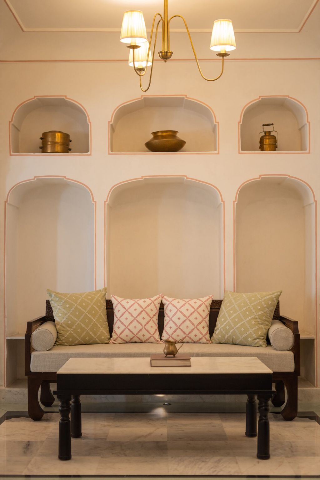 Suite sitting area with arched wall niches, brass pots and a marble-topped table, Padmaa, Jaipur
