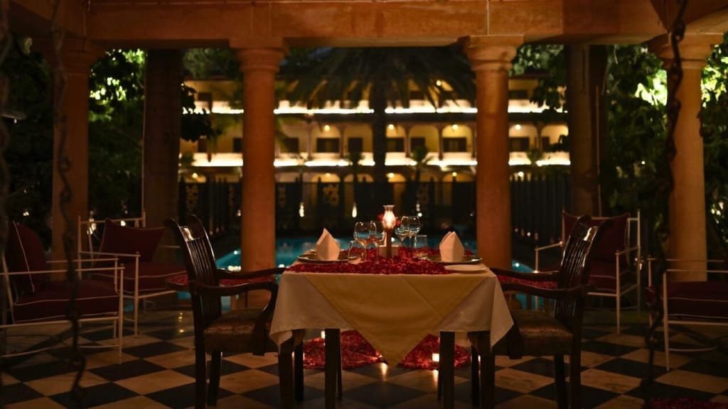 Red-sandstone palace facade lit at night, seen across the pool from the baradari, Ranbanka Palace, Jodhpur