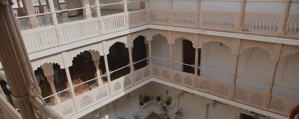 Tiered courtyard balconies with carved arches and lattice screens, Talabgaon Castle, Talabgaon