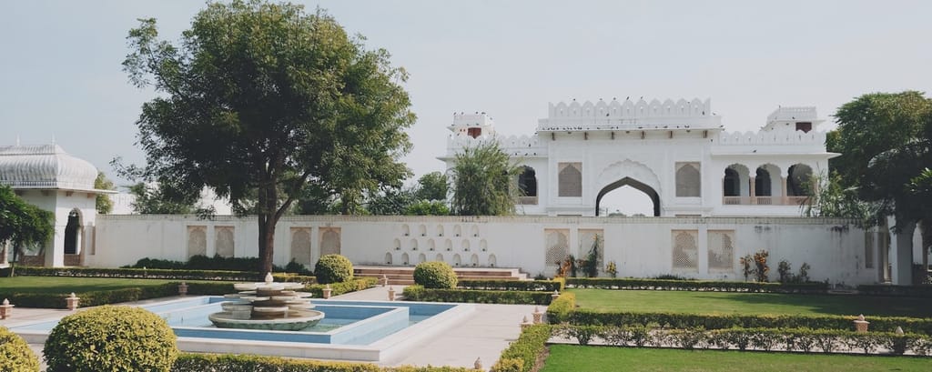 Castle gardens with fountain, parterre lawns and gatehouse beyond, Talabgaon Castle, Talabgaon