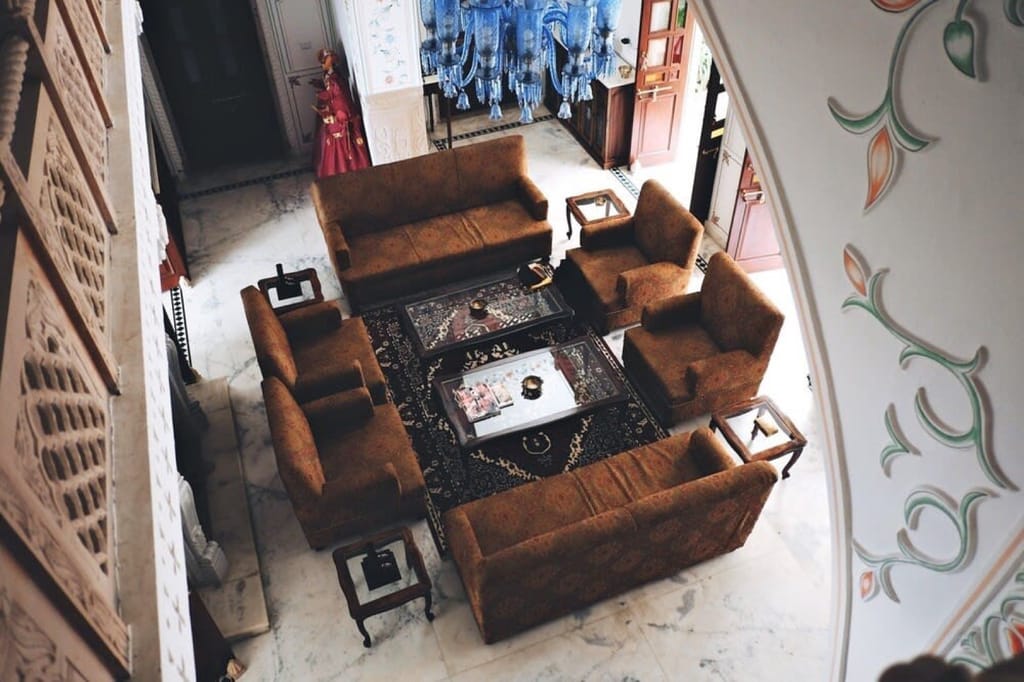 Sitting hall seen from above with sofas and blue glass chandeliers, Talabgaon Castle, Talabgaon