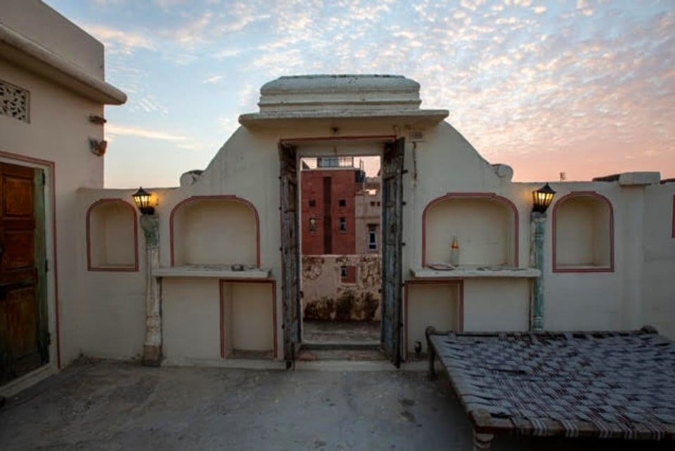 The rooftop at dusk, with its alcoves and charpoy