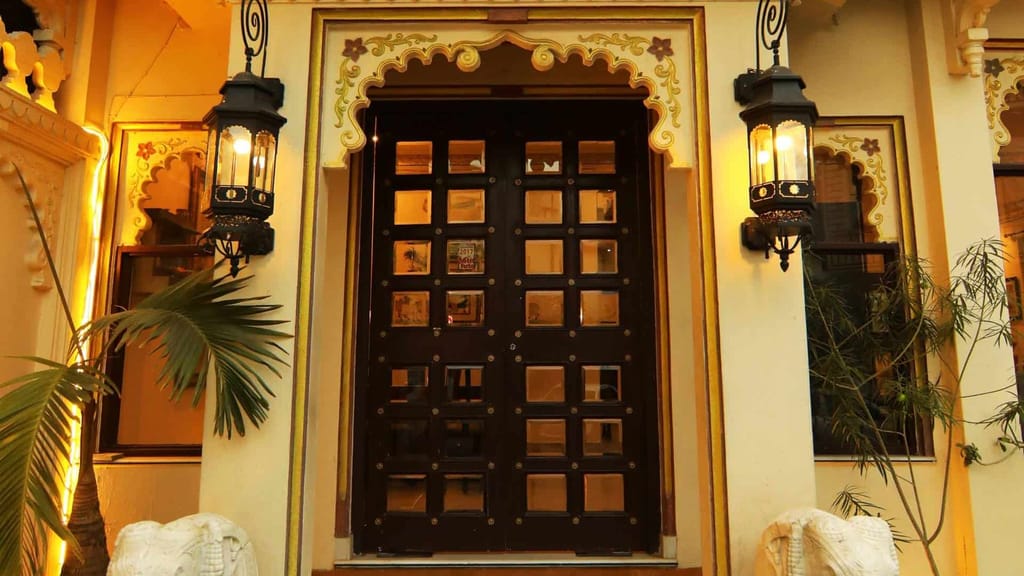 Massive carved wooden door flanked by lanterns