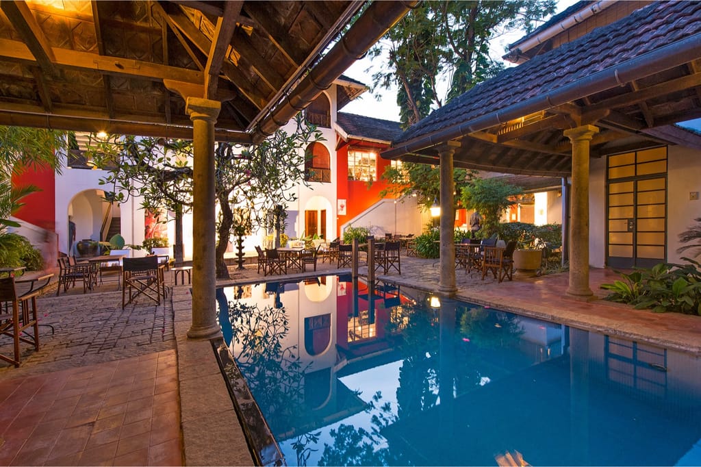 The Malabar House courtyard pool at dusk, lit under the tiled roof of the patio restaurant, Fort Cochin