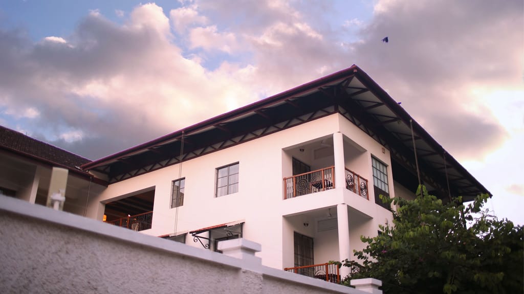 White contemporary exterior of Eighth Bastion with balconies and deep eaves at dusk