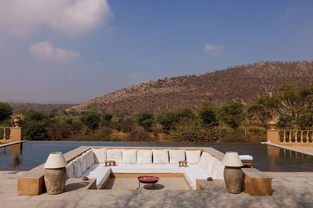 Infinity pool with white daybeds facing hills