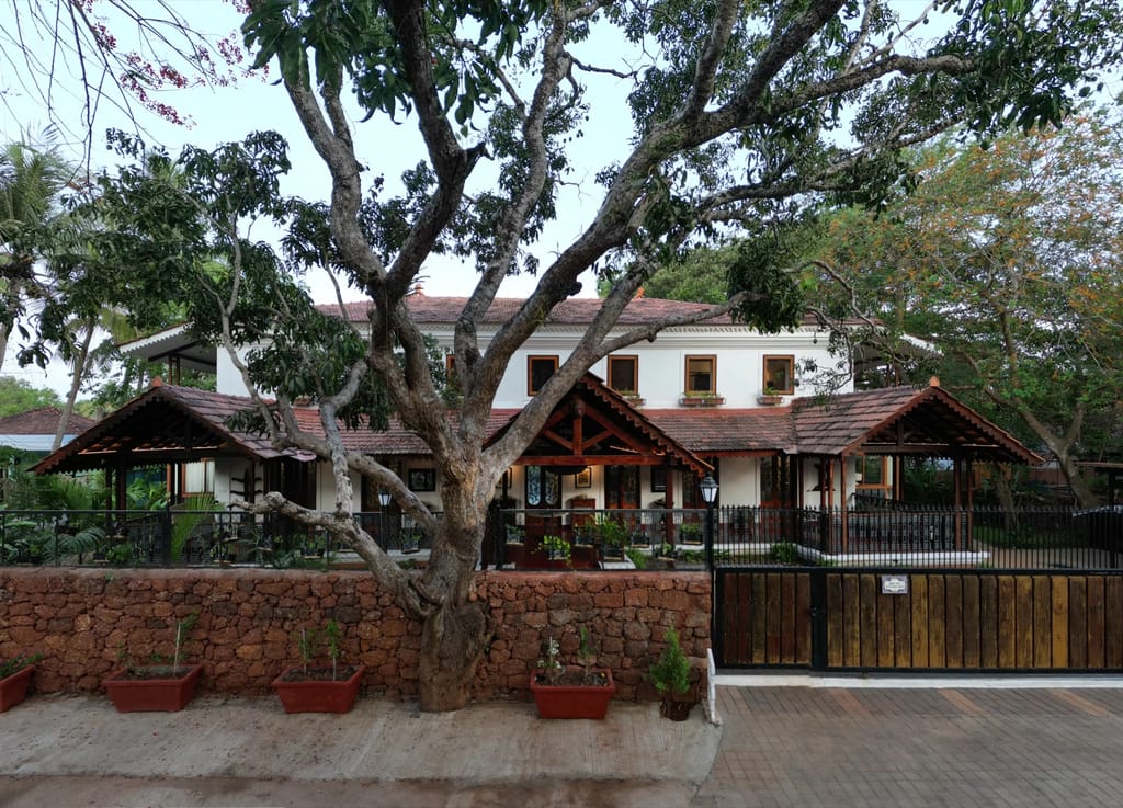 White house behind a laterite wall and old tree