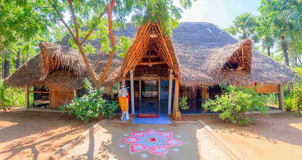 Thatched entrance pavilion with kolam on the ground