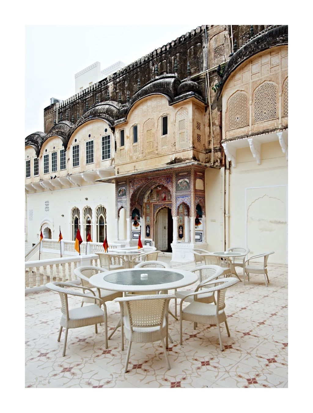 Courtyard tables below a carved facade