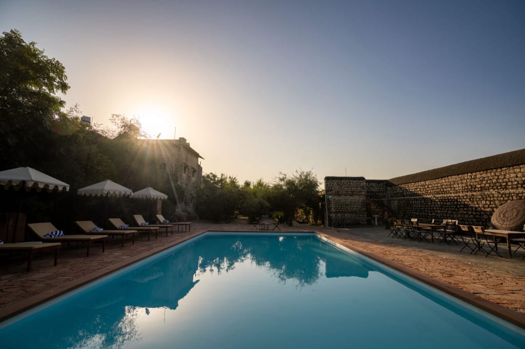 Swimming pool with sun umbrellas at dusk