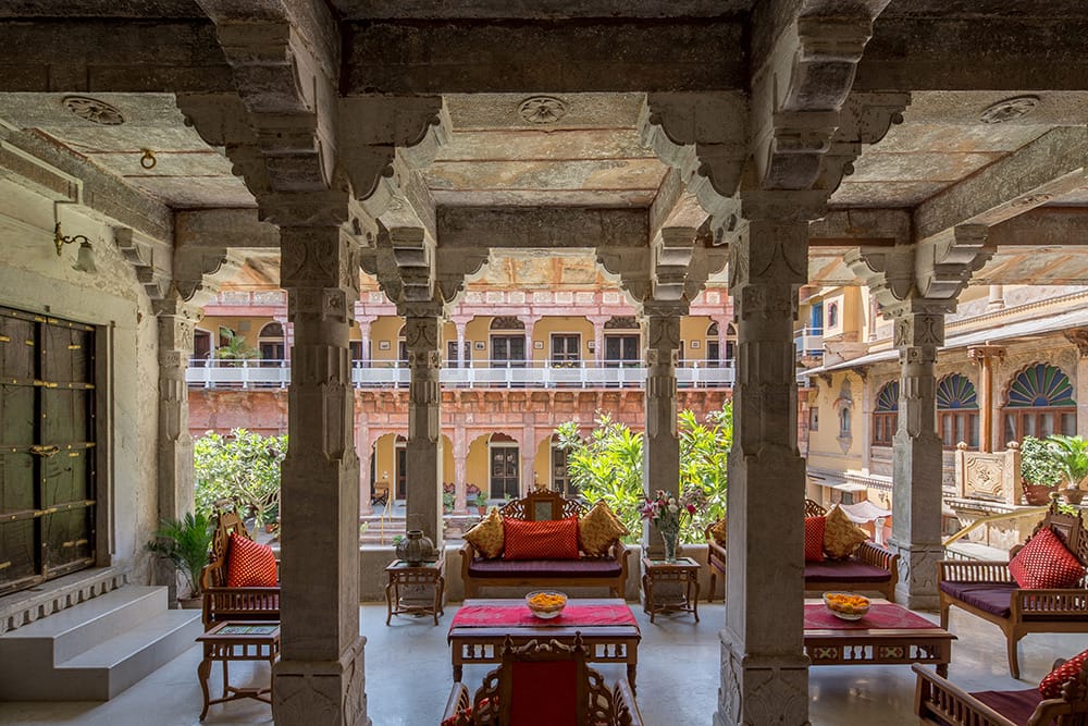 Pillared verandah with red cushioned benches looking out across the courtyard