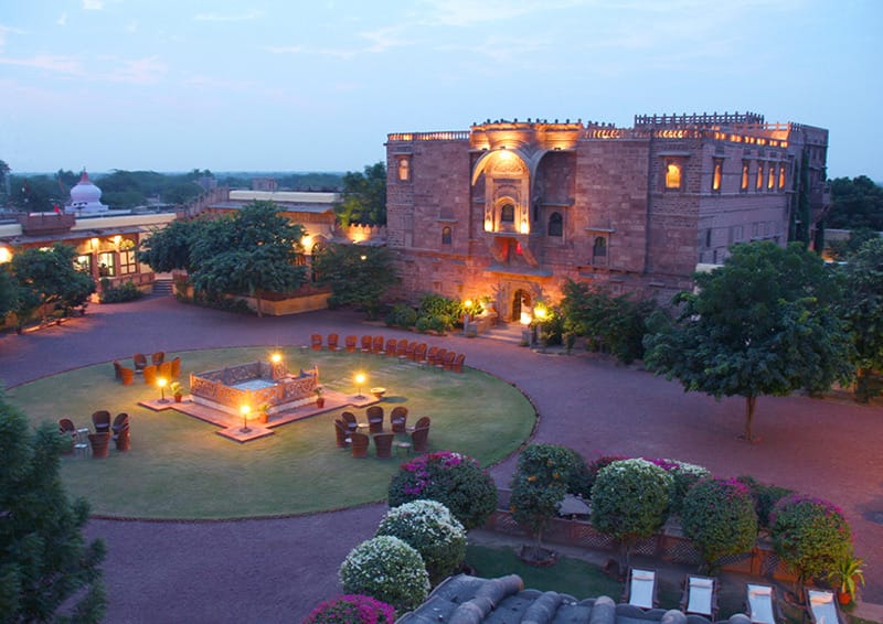 Haveli lit at dusk above its gardens