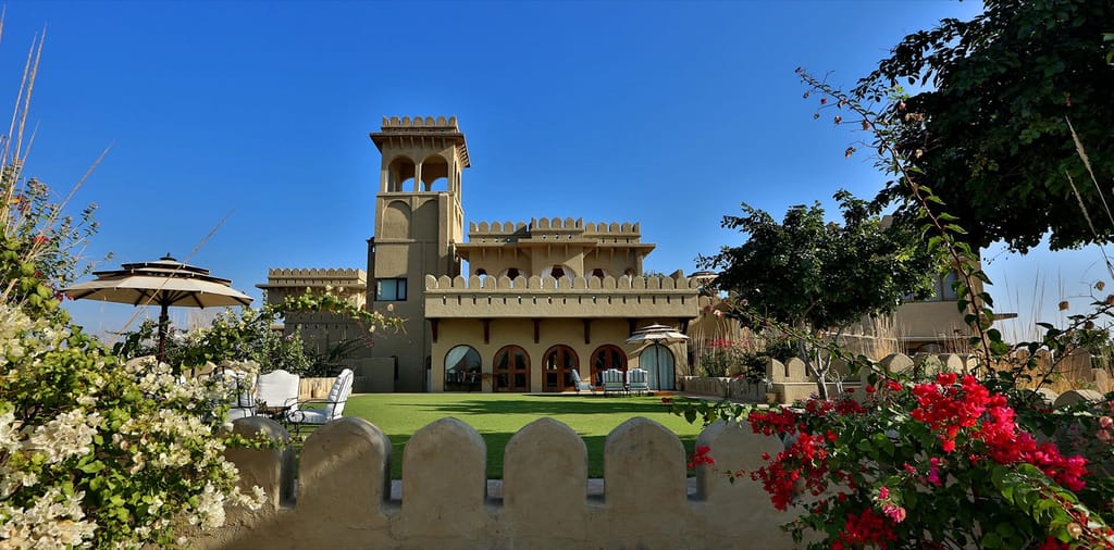 Fort walls above lawn and bougainvillea