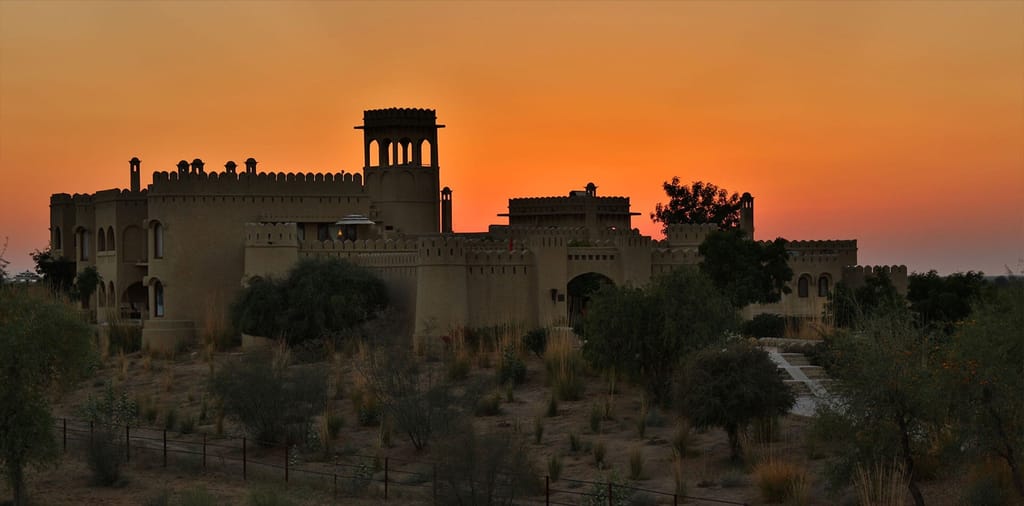 Fort silhouetted against a desert sunset