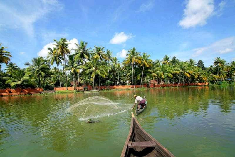 Fisherman casting a net from a canoe on the backwater