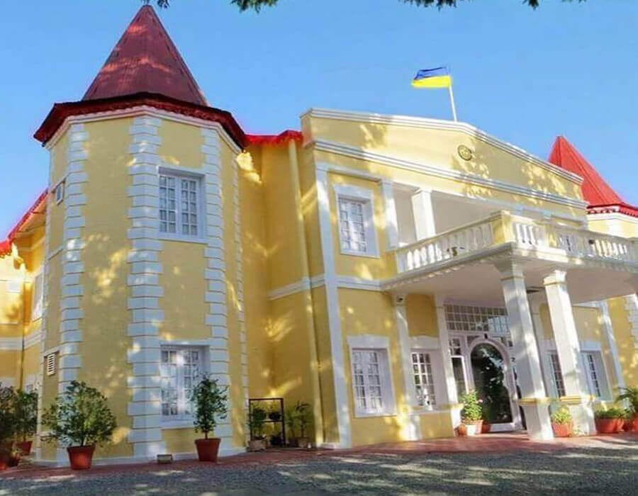 Yellow palace facade with conical turret roofs