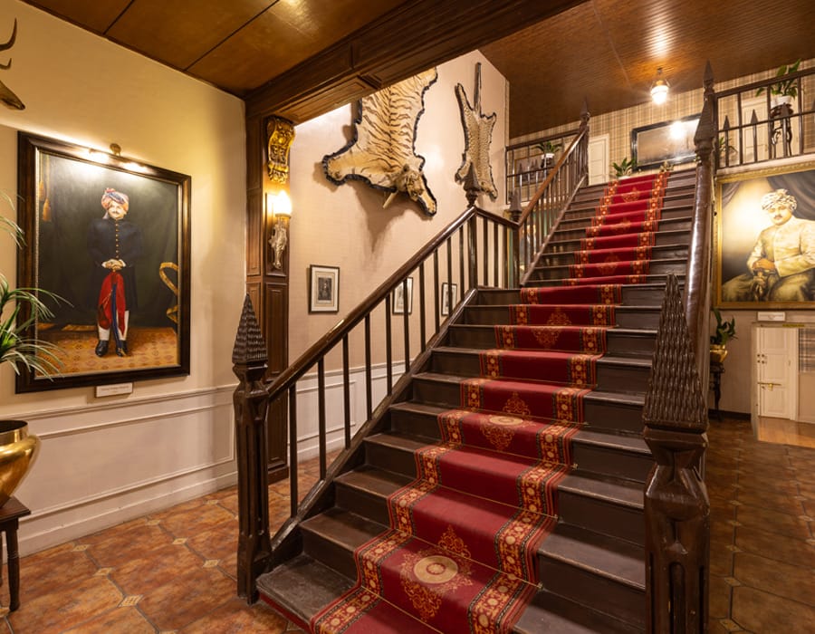 Staircase with red runner and mounted trophies