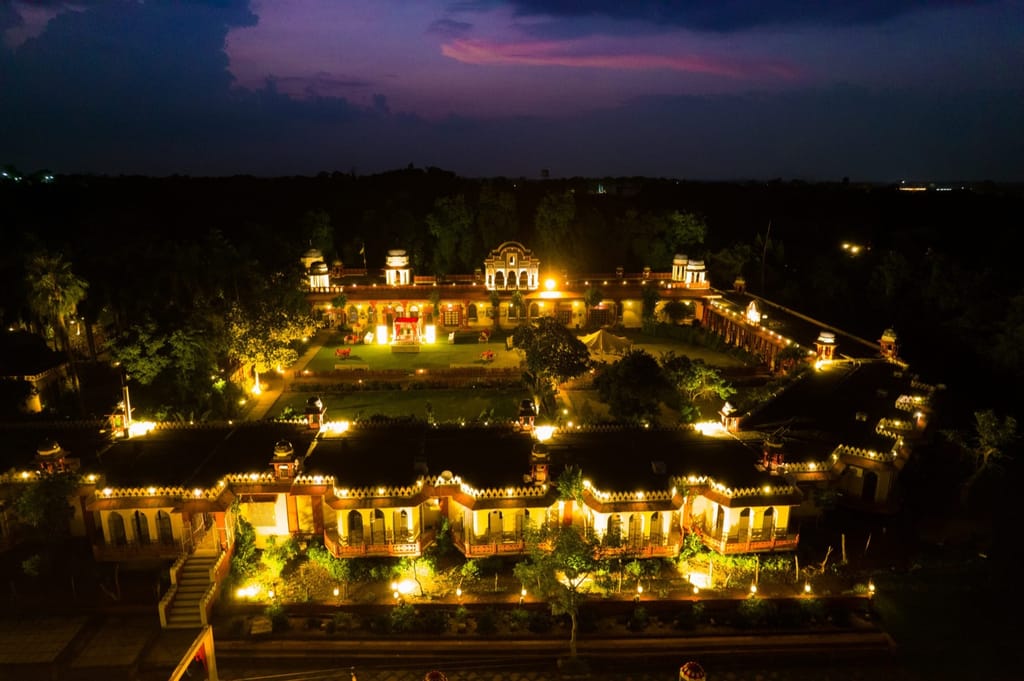 The property lit at night from above, showing the courtyard layout