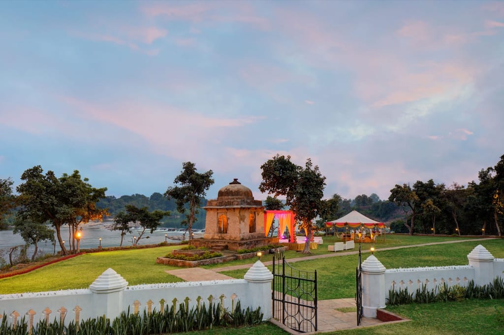 Stone cenotaph on the lawn at dusk with the river beyond