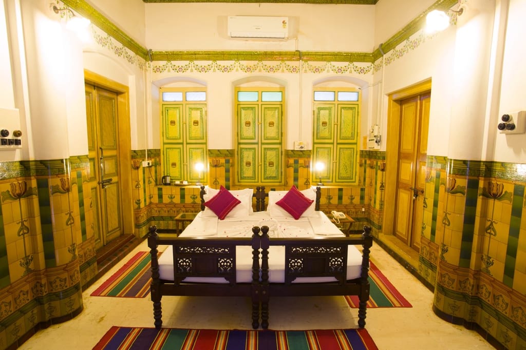 Bedroom with green shuttered doors and painted dado