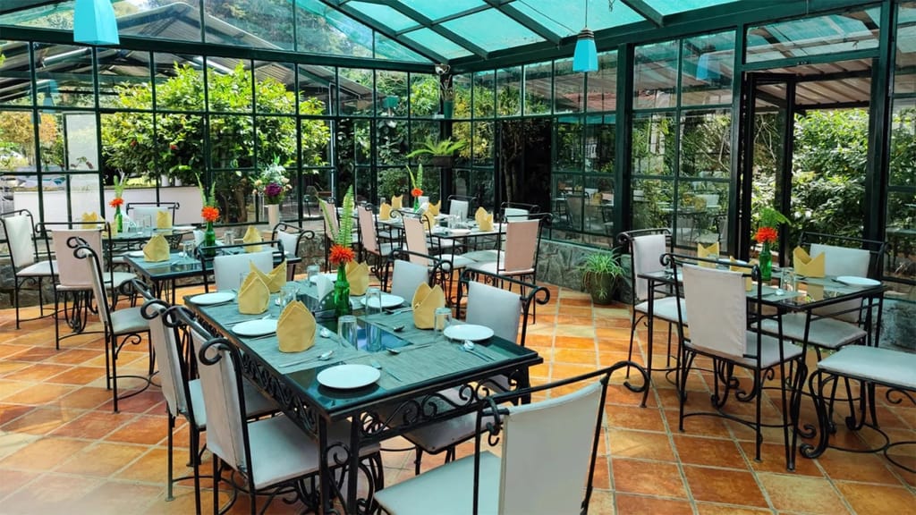 Glass house dining room with laid tables