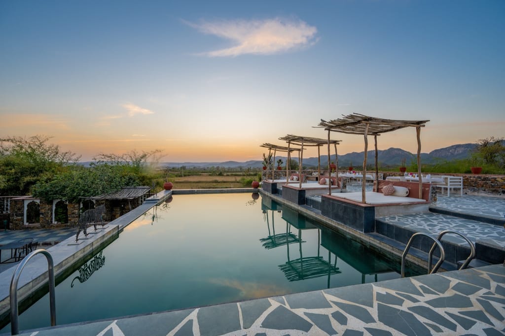 Swimming pool and shaded day beds at sunset
