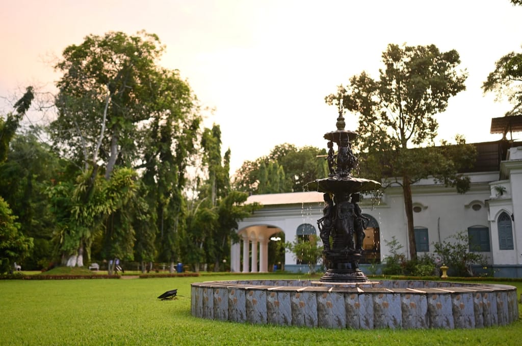 Fountain on the lawn with the manor behind