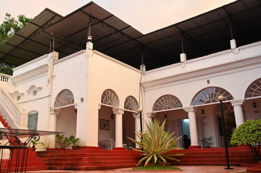 White portico with arches and red painted steps