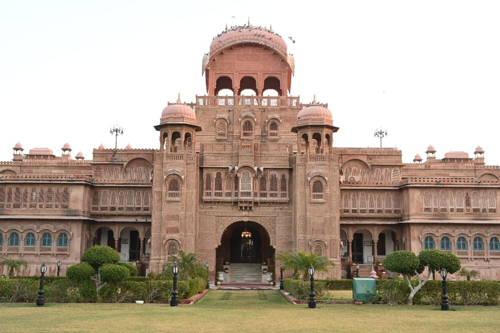 Palace entrance front with carved central dome, chhatris and topiary drive