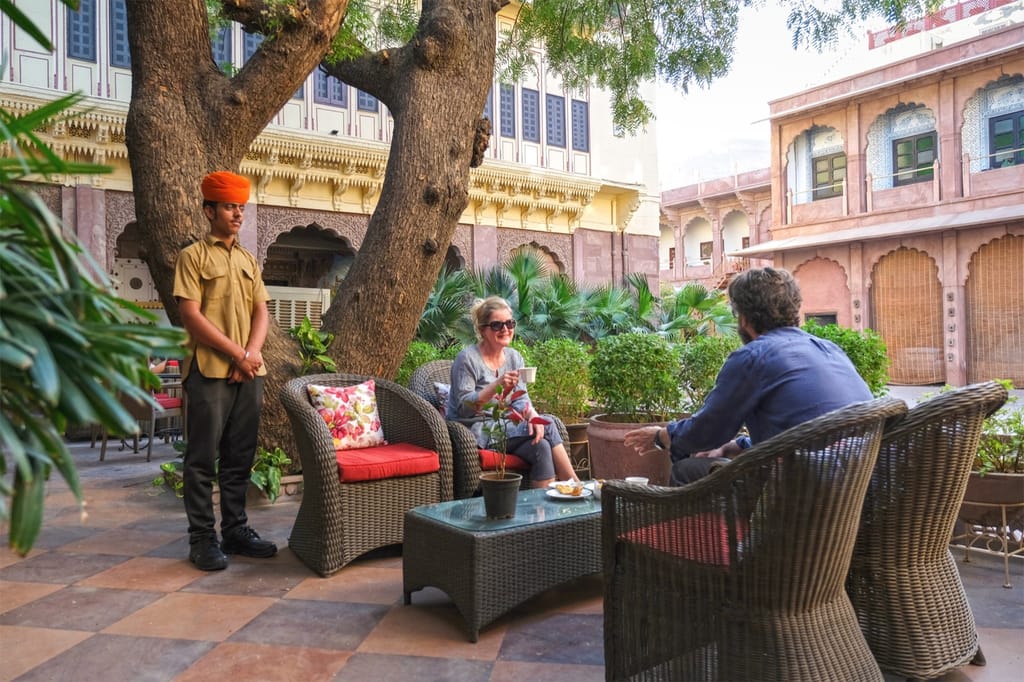 Courtyard seating under a tree below the haveli