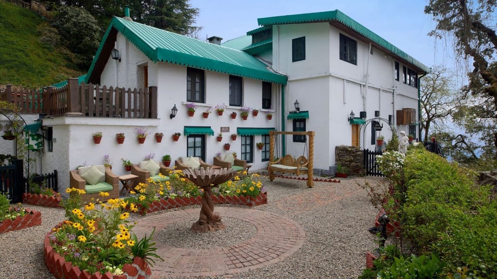 Green-roofed manor buildings around a flowering garden