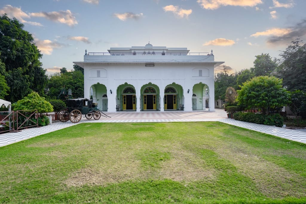 White arched pavilion and vintage carriage on the palace lawns