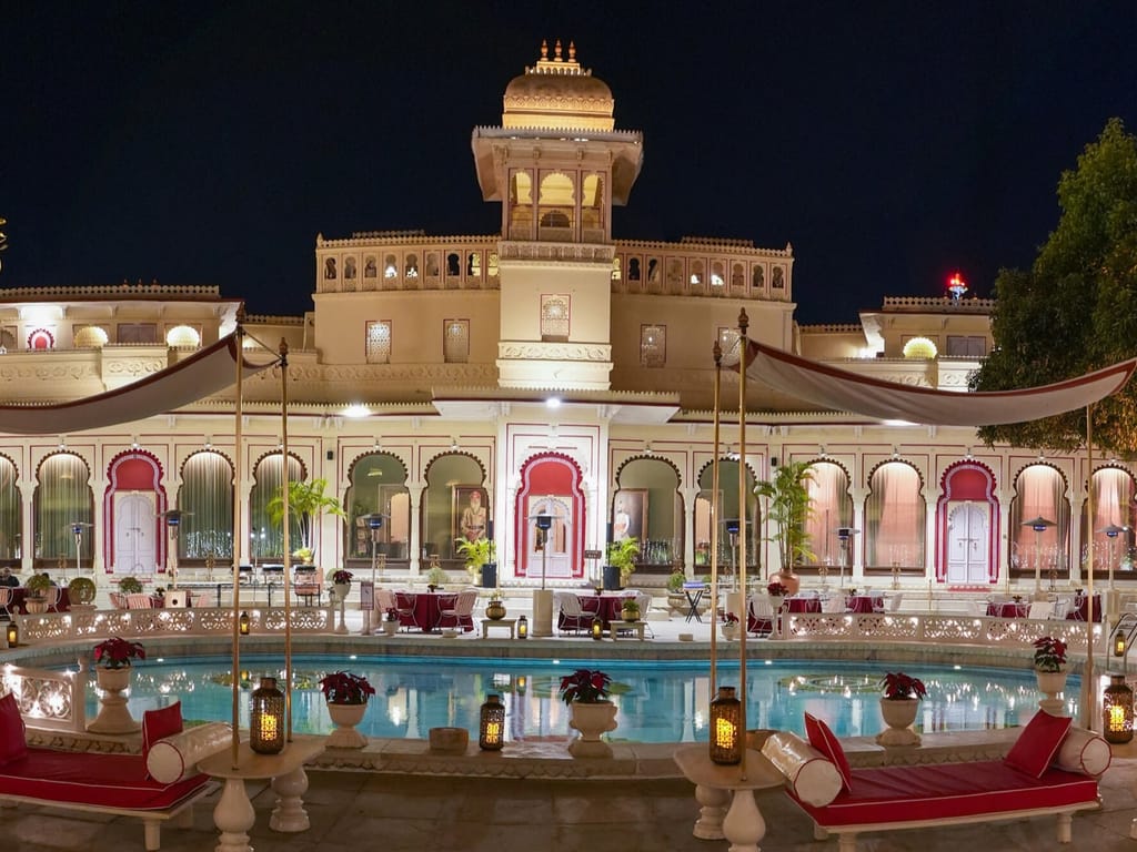 Lit palace and swimming pool at night